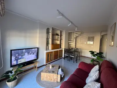 a living room with a couch and a tv at Duplex Olas de Ribadeo in Ribadeo
