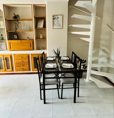 a dining room with a table and chairs and a staircase at Duplex Olas de Ribadeo in Ribadeo