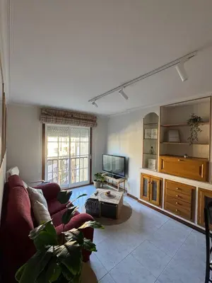 a living room with a couch and a tv at Duplex Olas de Ribadeo in Ribadeo