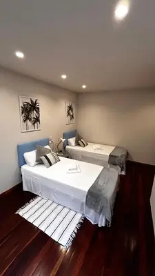 two beds in a room with wooden floors at Duplex Olas de Ribadeo in Ribadeo