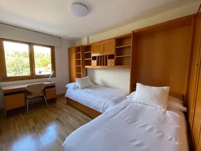 a bedroom with two beds and a desk with a desk at Los Balcones de Vega in Vega de Espinareda