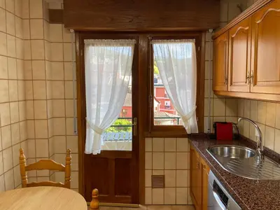 a kitchen with a door with a window and a sink at Los Balcones de Vega in Vega de Espinareda