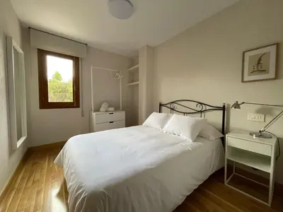 a bedroom with a white bed and a window at Los Balcones de Vega in Vega de Espinareda
