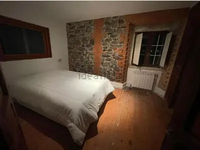 a bedroom with a bed and a brick wall at Somiedoeco in Caunedo