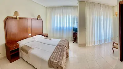 a bedroom with a large bed and a large window at Hostal La Cubana in Carballino