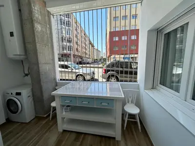 a kitchen with a counter in a room with a window at Apartamentos Torres del Milladoiro in Amés