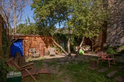 a yard with benches and chairs in front of a building at Arzipreste II Casa del Ama in León