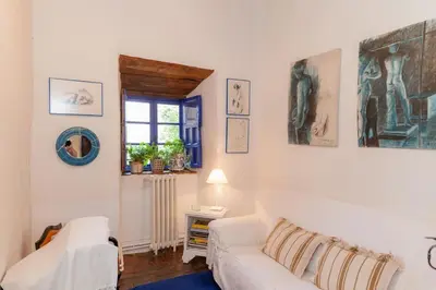 a living room with a white couch and a window at Arzipreste II Casa del Ama in León