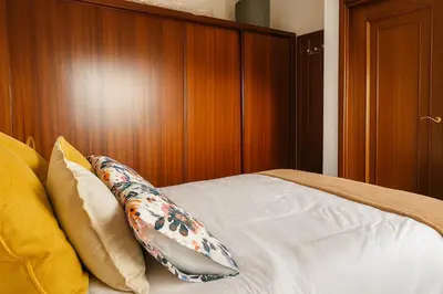 a bedroom with a bed with a wooden headboard at Casa Vixoi, a 5Km Catedral in Santiago de Compostela