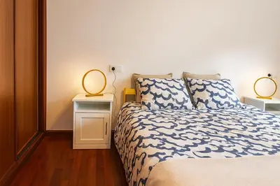 a bedroom with a bed with two lamps on it at Casa Vixoi, a 5Km Catedral in Santiago de Compostela