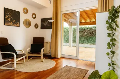 two chairs in a living room with a sliding glass door at Casa Vixoi, a 5Km Catedral in Santiago de Compostela