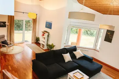 a living room with a black couch at Casa Vixoi, a 5Km Catedral in Santiago de Compostela