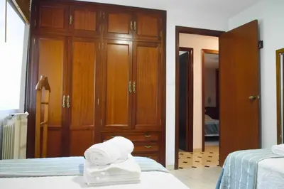 a bedroom with two beds and wooden cabinets at Casa Ermitas - Relájate en plena naturaleza in A Estrada