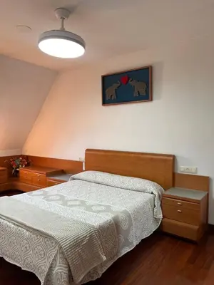 a bedroom with a bed with a white bedspread at O piso de Cris in Caldas de Reis