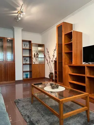a living room with a coffee table and wooden shelves at O piso de Cris in Caldas de Reis