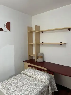 a bedroom with a bed and shelves on the wall at O piso de Cris in Caldas de Reis