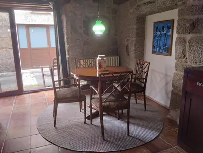 a wooden table and chairs in a room at O Recuncho da Isa - Ribeira Sacra in Pereiro de Aguiar
