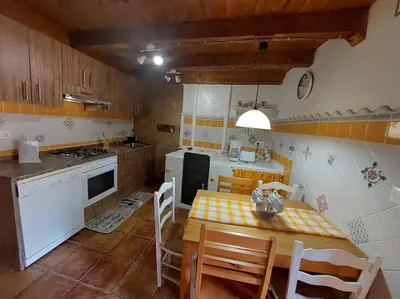a kitchen with a table and a table and chairs at O Recuncho da Isa - Ribeira Sacra in Pereiro de Aguiar