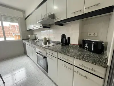 a kitchen with white cabinets and a counter top at YourHouse Maca I in Ourense