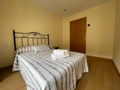 a bedroom with a large bed with a striped blanket at YourHouse Maca I in Ourense