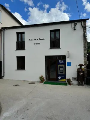 a white building with the front door open at Boutique Vila de Triacastela in Tríacastela
