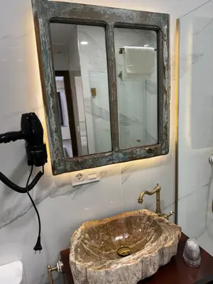 a bathroom with a stone sink and a mirror at Boutique Vila de Triacastela in Tríacastela