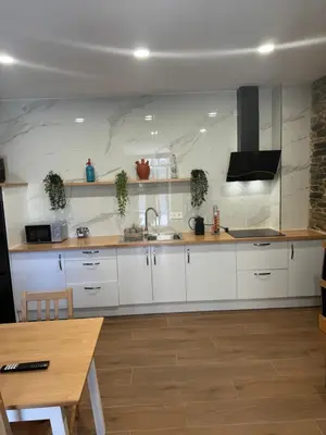 a kitchen with white cabinets and a sink at Boutique Vila de Triacastela in Tríacastela