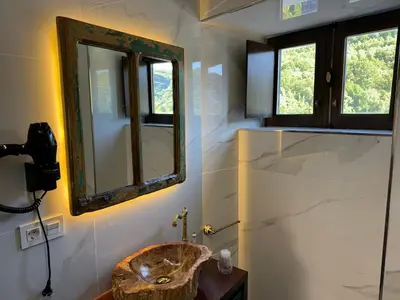 a bathroom with a sink and a mirror at Boutique Vila de Triacastela in Tríacastela