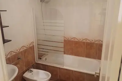 a bathroom with a sink and a tub and a toilet at Apartamento céntrico in Foz