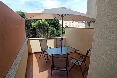 a table and chairs with an umbrella on a balcony at Apartamento céntrico in Foz