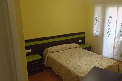 a small bedroom with a bed and a window at Apartamento céntrico in Foz