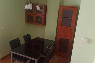 a dining room with a table and chairs and a cabinet at Apartamento céntrico in Foz