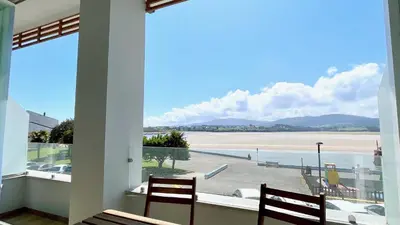 a room with a view of a beach from a window at The Cliffs A Ribeira - Polas in Foz
