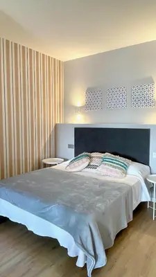 a bedroom with a large bed and two tables at The Cliffs A Ribeira - Polas in Foz