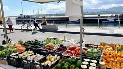 a farmers market with fruits and vegetables on a boat at The Cliffs A Ribeira - Polas in Foz