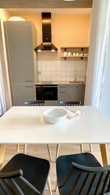 a kitchen with a white table and two chairs at The Cliffs A Ribeira - Polas in Foz