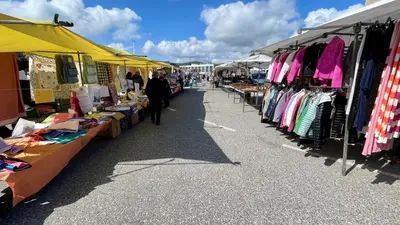 a market with a bunch of tables filled with clothes at The Cliffs A Ribeira - Llas in Foz