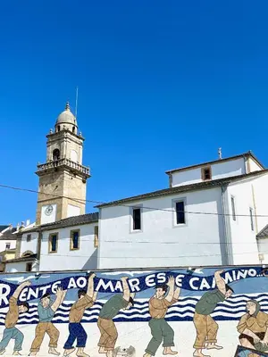 a mural on the side of a building with a clock tower at The Cliffs A Ribeira - Areoura in Foz