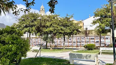 a park with benches and trees in front of a building at The Cliffs A Ribeira - Areoura in Foz