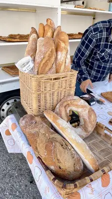 a bunch of loaves of bread in baskets on a table at The Cliffs A Ribeira - Areoura in Foz