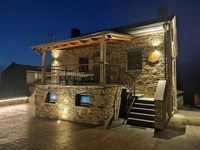 a stone house with a porch and a staircase at Apartamentos Rurales Torre de la Alcandra - 3 llaves - Asturias in Vegadeo