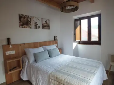 a bedroom with a bed and a window at Apartamentos Rurales Torre de la Alcandra - 3 llaves - Asturias in Vegadeo