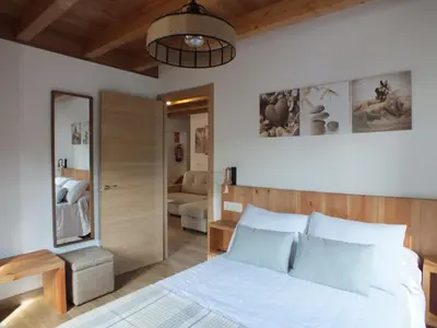 a bedroom with a bed and a living room at Apartamentos Rurales Torre de la Alcandra - 3 llaves - Asturias in Vegadeo