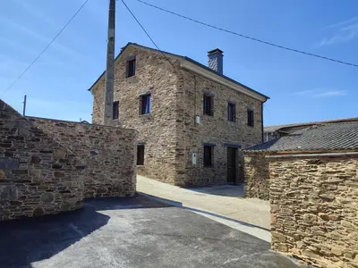 an old stone building with two stone walls at Apartamentos Rurales Torre de la Alcandra - 3 llaves - Asturias in Vegadeo