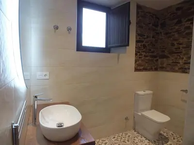 a bathroom with a white toilet and a window at Apartamentos Rurales Torre de la Alcandra - 3 llaves - Asturias in Vegadeo
