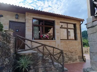 a stone house with a window and a staircase at Casa Labrega da Torre in Silleda