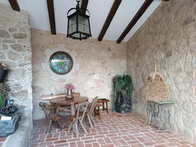 a room with a table and chairs in a stone wall at Casa Labrega da Torre in Silleda