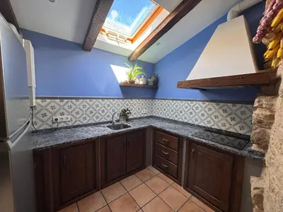 a kitchen with blue walls and a sink and a window at Casa Labrega da Torre in Silleda