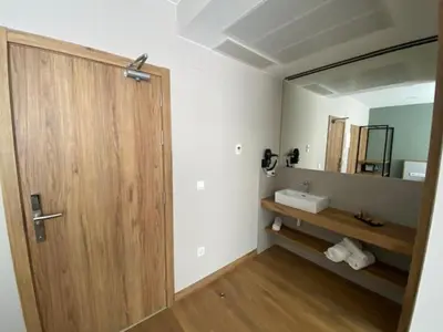 a bathroom with a wooden door and a sink at La Finca in Lugo