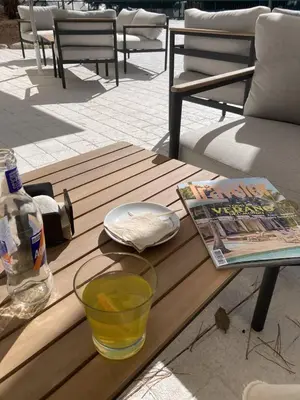 a wooden table with a book and a drink on it at La Finca in Lugo